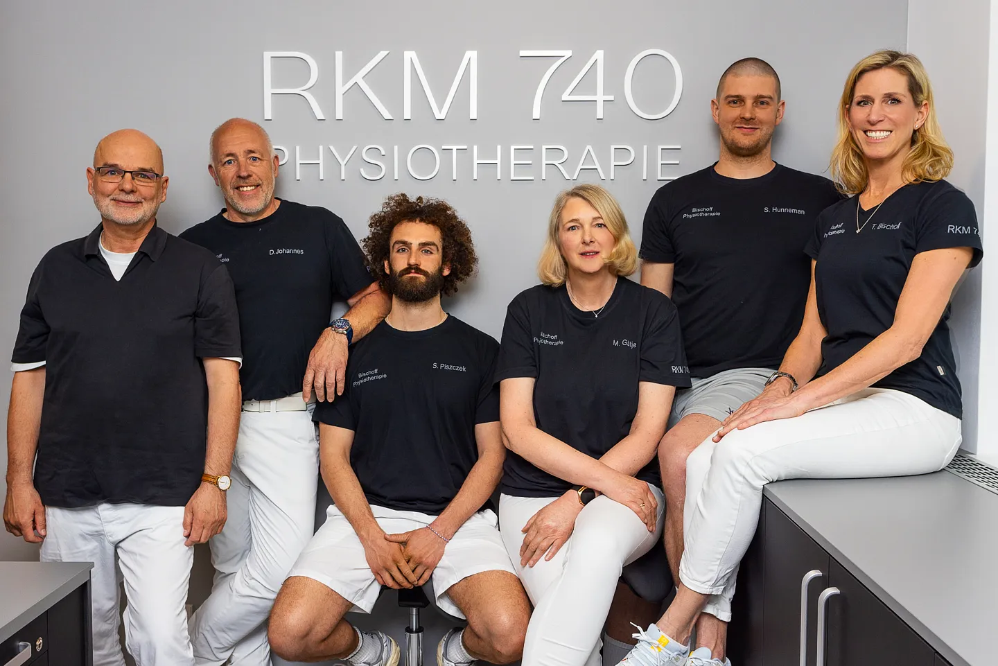 Team der RKM 740 Physiotherapie Düsseldorfvor dem Praxislogo
