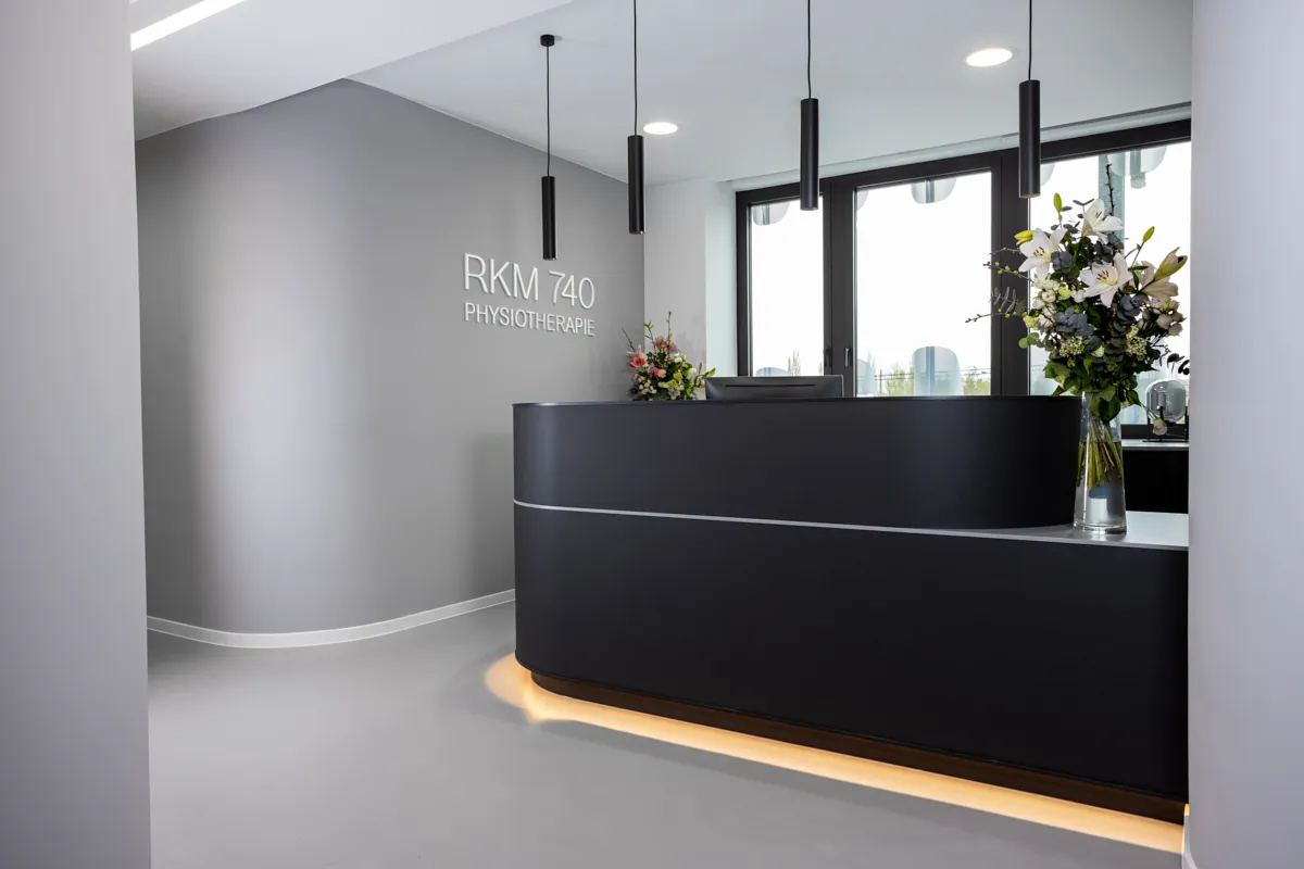 Moderner Empfangsbereich der RKM 740 Physiotherapie Düsseldorf mit Blumenarrangement