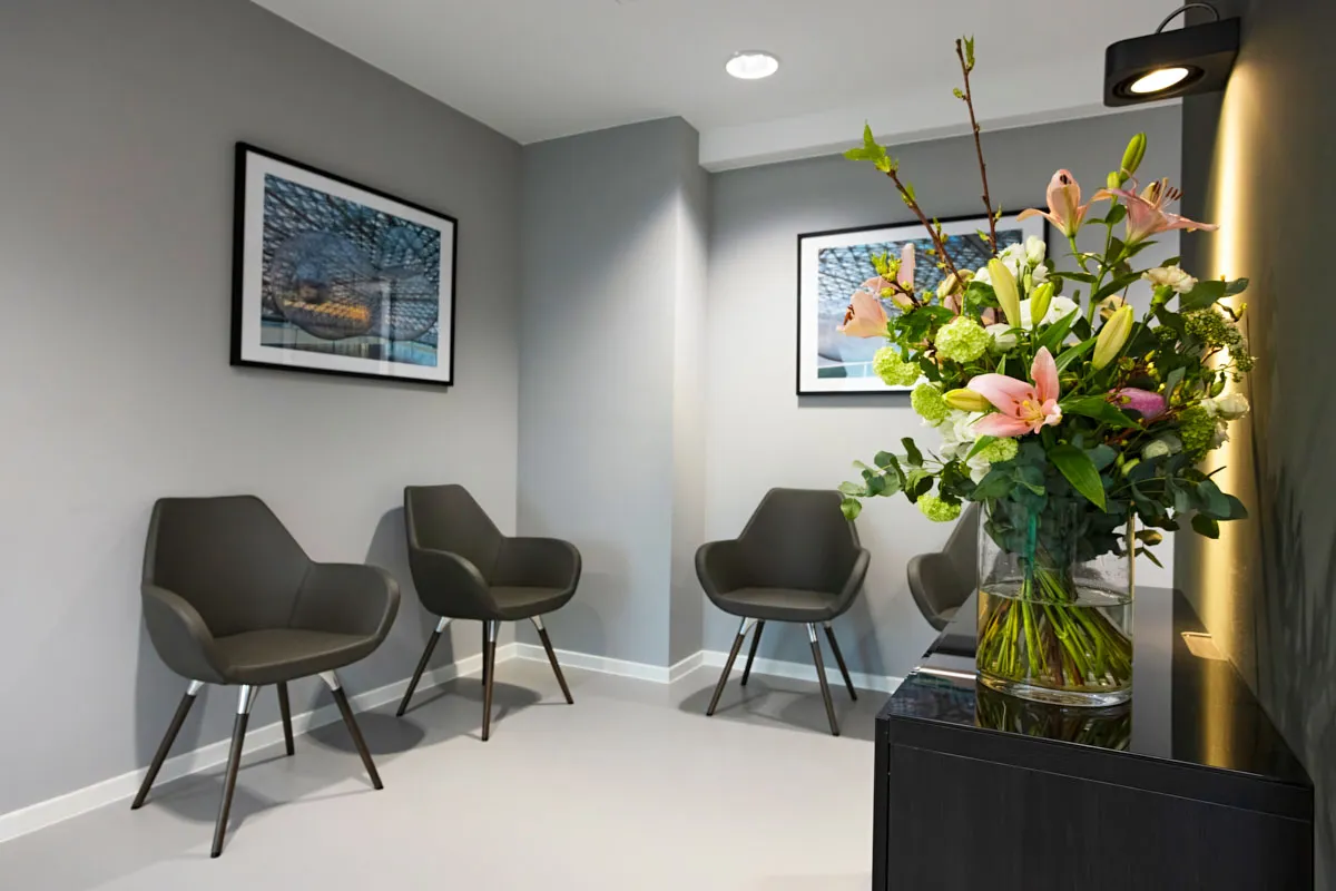 Warteraum der RKM 740 Physiotherapie Düsseldorf mit modernen Stühlen und frischem Blumenarrangement